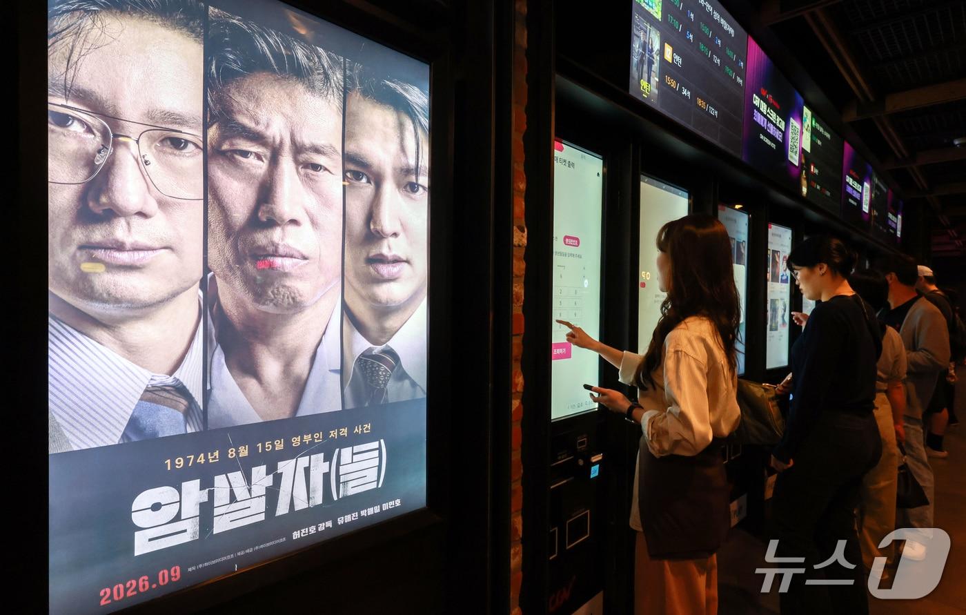본문 이미지 - 영화 '암살자(들)'이 역사 왜곡 논란 속에서 누적 관객 수 223만 명을 돌파했다. 5일 영화진흥위원회 영화관입장권 통합전산망에 따르면 '암살자(들)'은 지난 2일부터 4일까지 주말 동안 41만 2012명의 관객을 동원했다. 누적 관객수는 223만 3963명이다. 사진은 이날 서울 시내 한 영화관에 걸린 '암살자(들)' 포스터의 모습. 2026.10.5 ⓒ 뉴스1 이호윤 기자