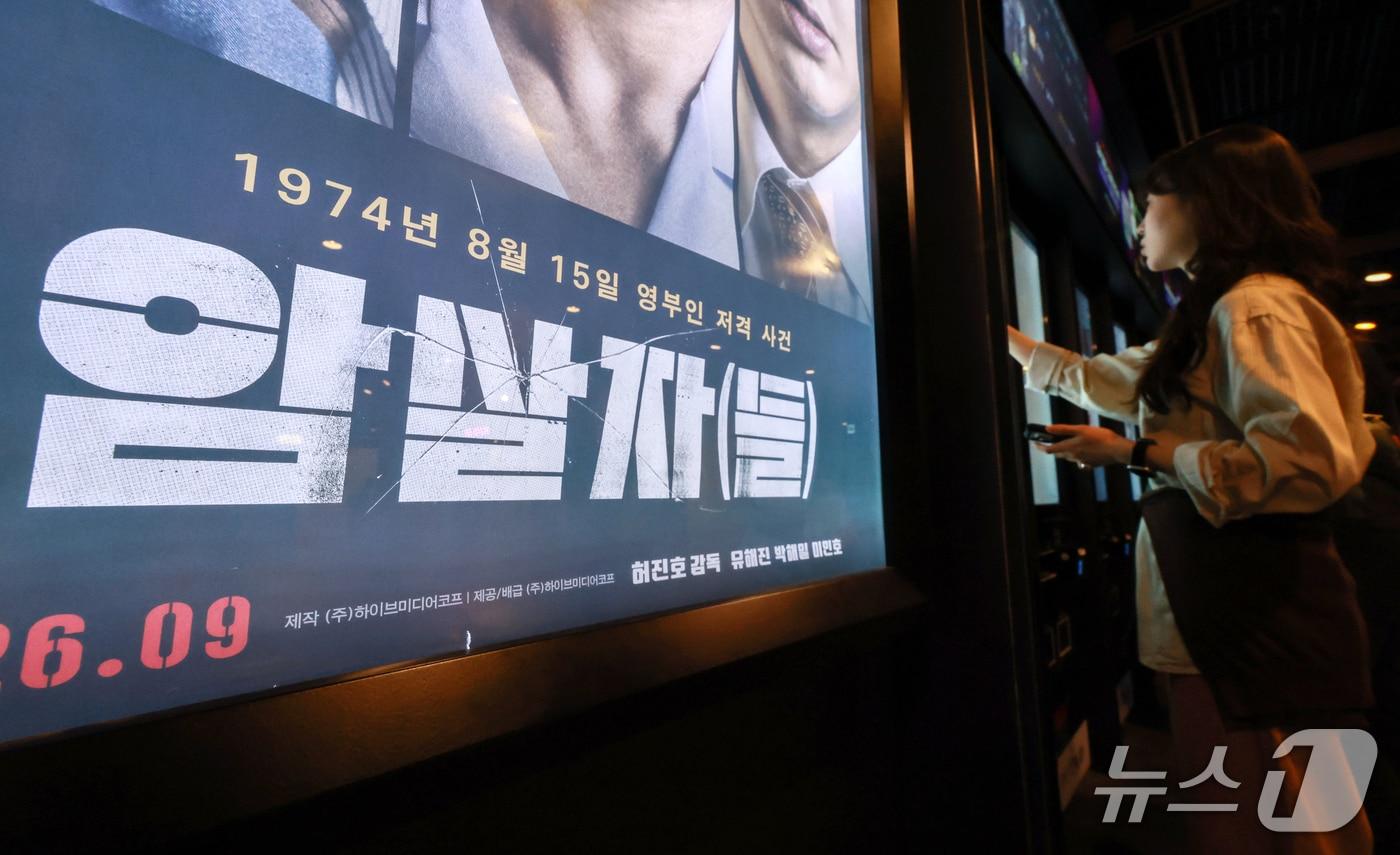 본문 이미지 - 영화 '암살자(들)'이 역사 왜곡 논란 속에서 누적 관객 수 223만 명을 돌파했다. 사진은 이날 서울 시내 한 영화관에 걸린 '암살자(들)' 포스터의 모습. 2026.10.5 ⓒ 뉴스1 이호윤 기자