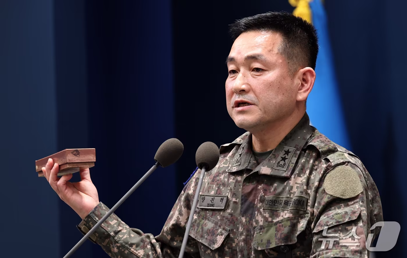 본문 이미지 - 양진혁 합동참모본부 작전부장이 5일 서울 용산구 국방부에서 북한군 수지반보병 지뢰를 들어보이며 육군 25사단 비무장지대(DMZ) 지뢰 폭발상황을 설명하고 있다. 2026.10.5 ⓒ 뉴스1 구윤성 기자