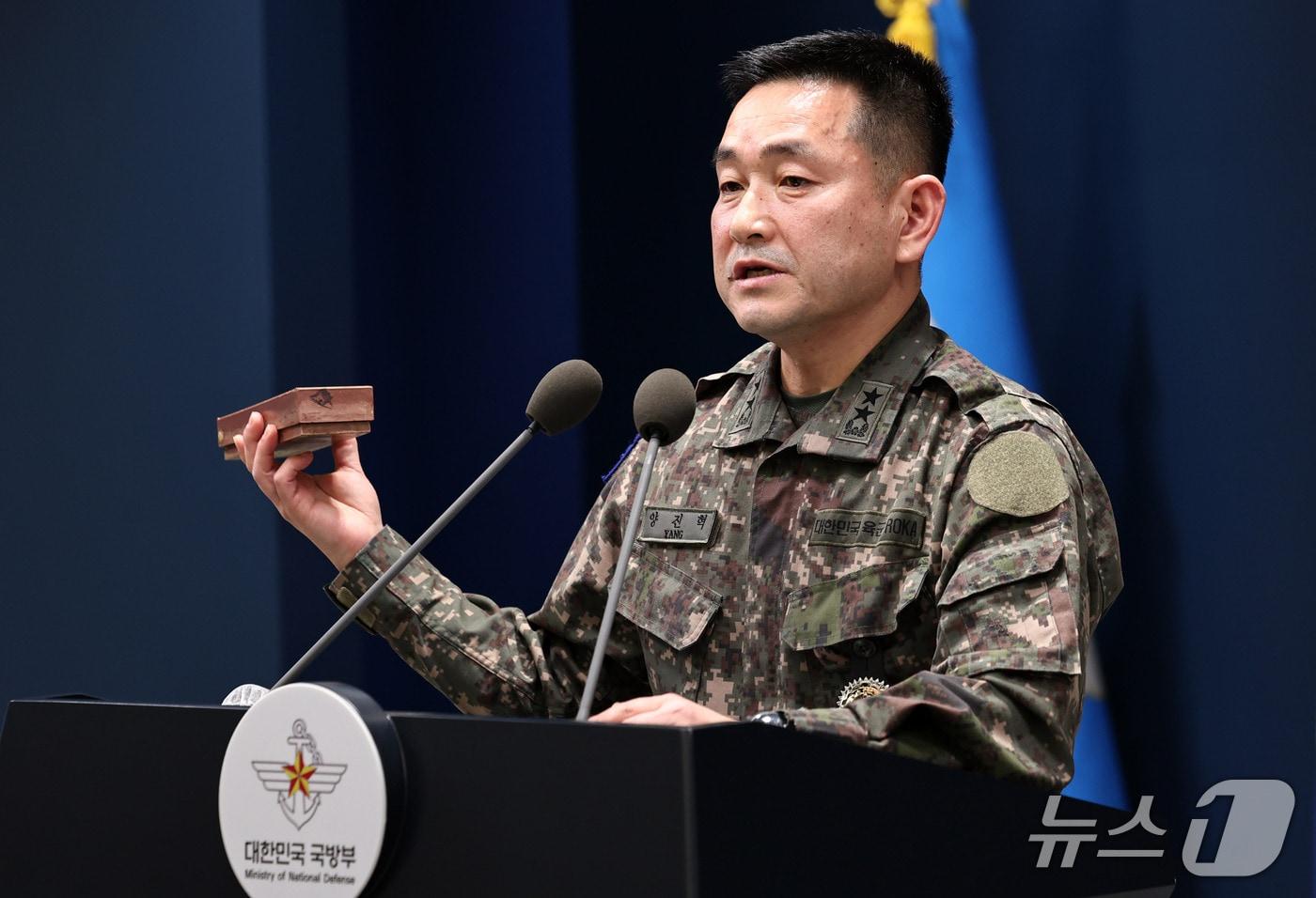 본문 이미지 - 양진혁 합동참모본부 작전부장이 5일 서울 용산구 국방부에서 북한군 수지반보병 지뢰를 들어보이며 육군 25사단 비무장지대(DMZ) 지뢰 폭발상황을 설명하고 있다. 2026.10.5 ⓒ 뉴스1 구윤성 기자