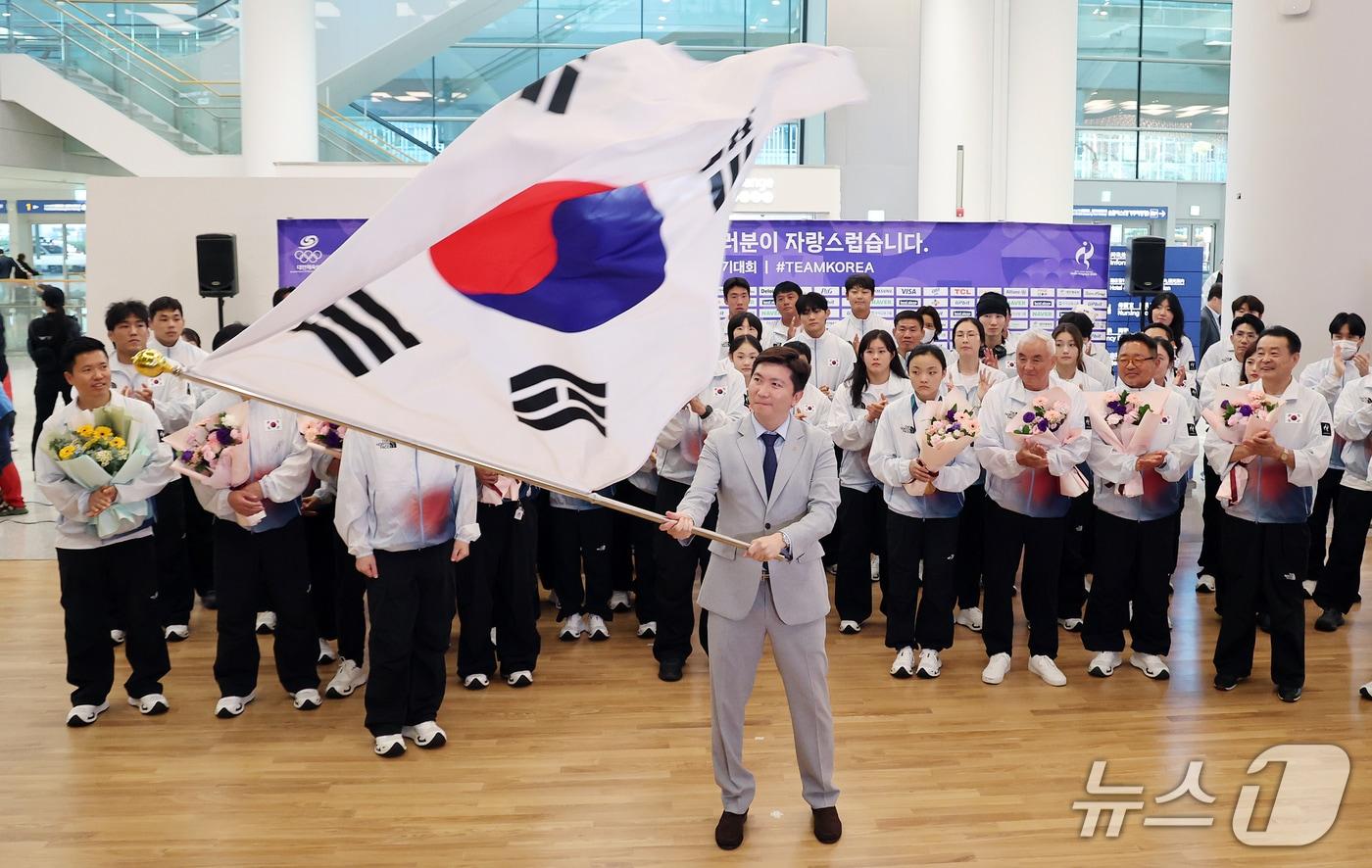 본문 이미지 - 유승민 대한체육회장이 5일 오후 인천국제공항 제2터미널에서 열린 2026 아이치·나고야 아시안게임에 출전한 대한민국 국가대표 선수단 해단식에서 선수단기를 흔들고 있다. 대한민국 선수단은 이번 대회에서 금메달 39개, 은메달 43개, 동메달 68개를 따내며 중국, 일본에 이어 종합 3위를 기록했다. 2026.10.5 ⓒ 뉴스1 김진환 기자