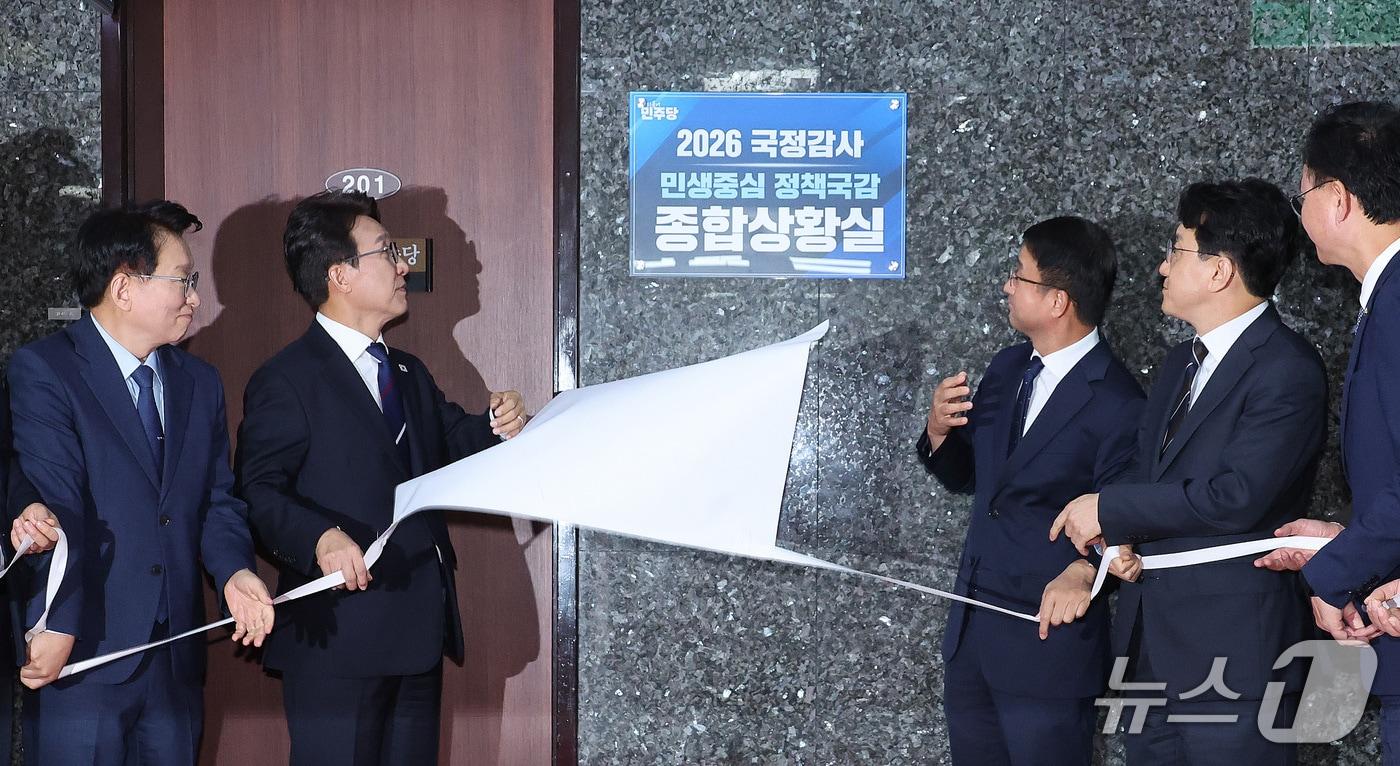 본문 이미지 - 김민석 더불어민주당 대표와 한병도 원내대표가 6일 서울 여의도 국회에서 열린 2026 국정감사 종합상황실 현판식에서 제막을 하고 있다. 2026.10.6 ⓒ 뉴스1 신웅수 기자