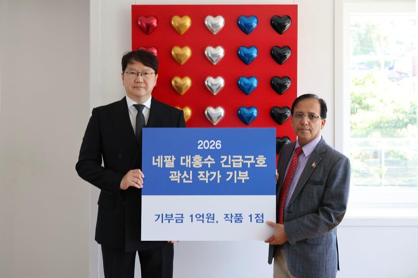 본문 이미지 - 6일 주한 네팔대사관에서 곽신 작가가 니르말 프라사드 버떠라이 주한네팔 대사대리에게 홍수 피해 복구를 위한 기부금 1억원과 작품 ‘Endless Love'를 전달했다. (한미반도체 제공).
