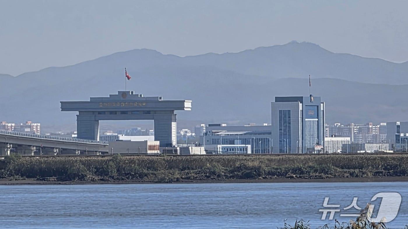 본문 이미지 - 지난 6일 중국 랴오닝성 단둥에서 바라본 신압록강대교 북한 측 세관 일대에 인공기가 휘날리고 있다. 2026.10.6 ⓒ 뉴스1 노민호 특파원