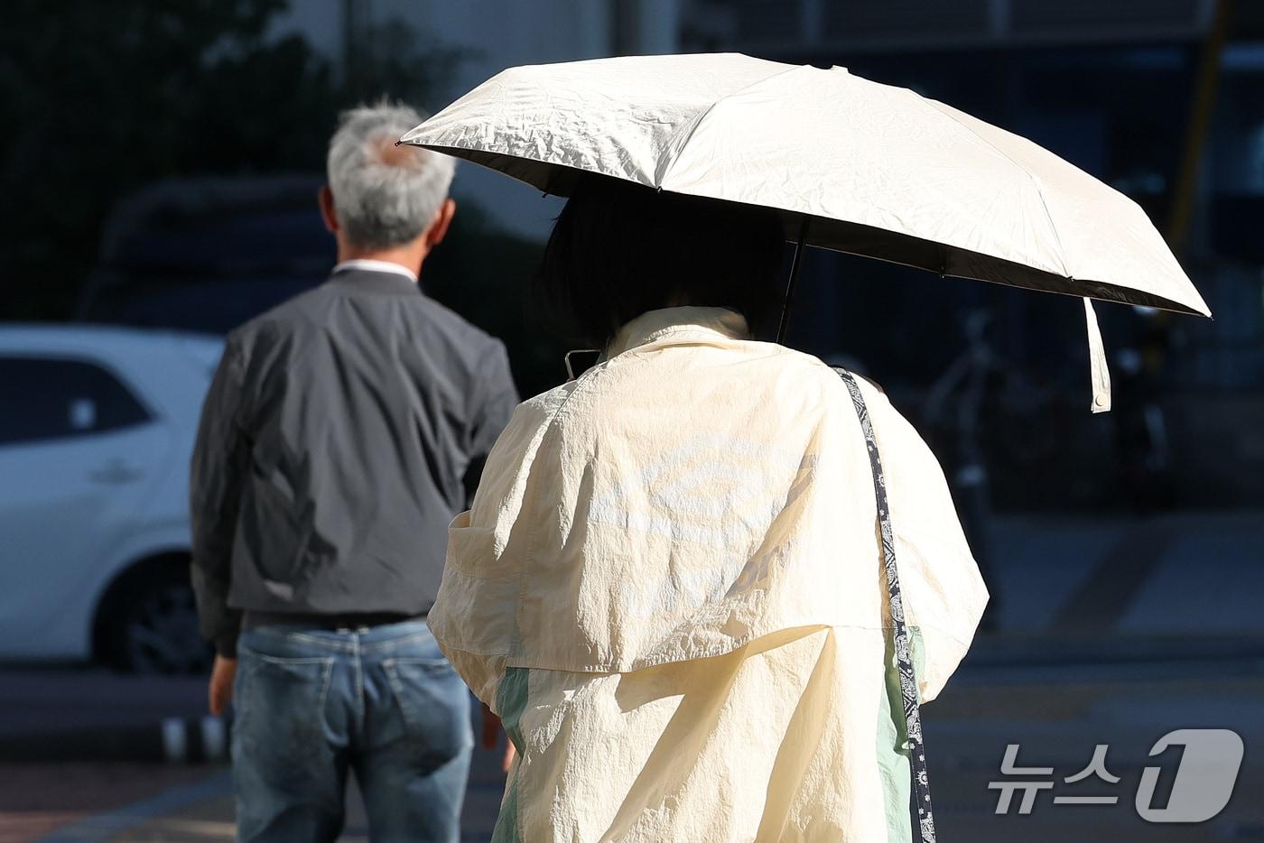 본문 이미지 - 대구 남구 명덕네거리에서 가을 점퍼 차림의 한 시민이 양산을 펼쳐 따가운 햇살을 가리고 있다. 2026.10.7 ⓒ 뉴스1 공정식 기자