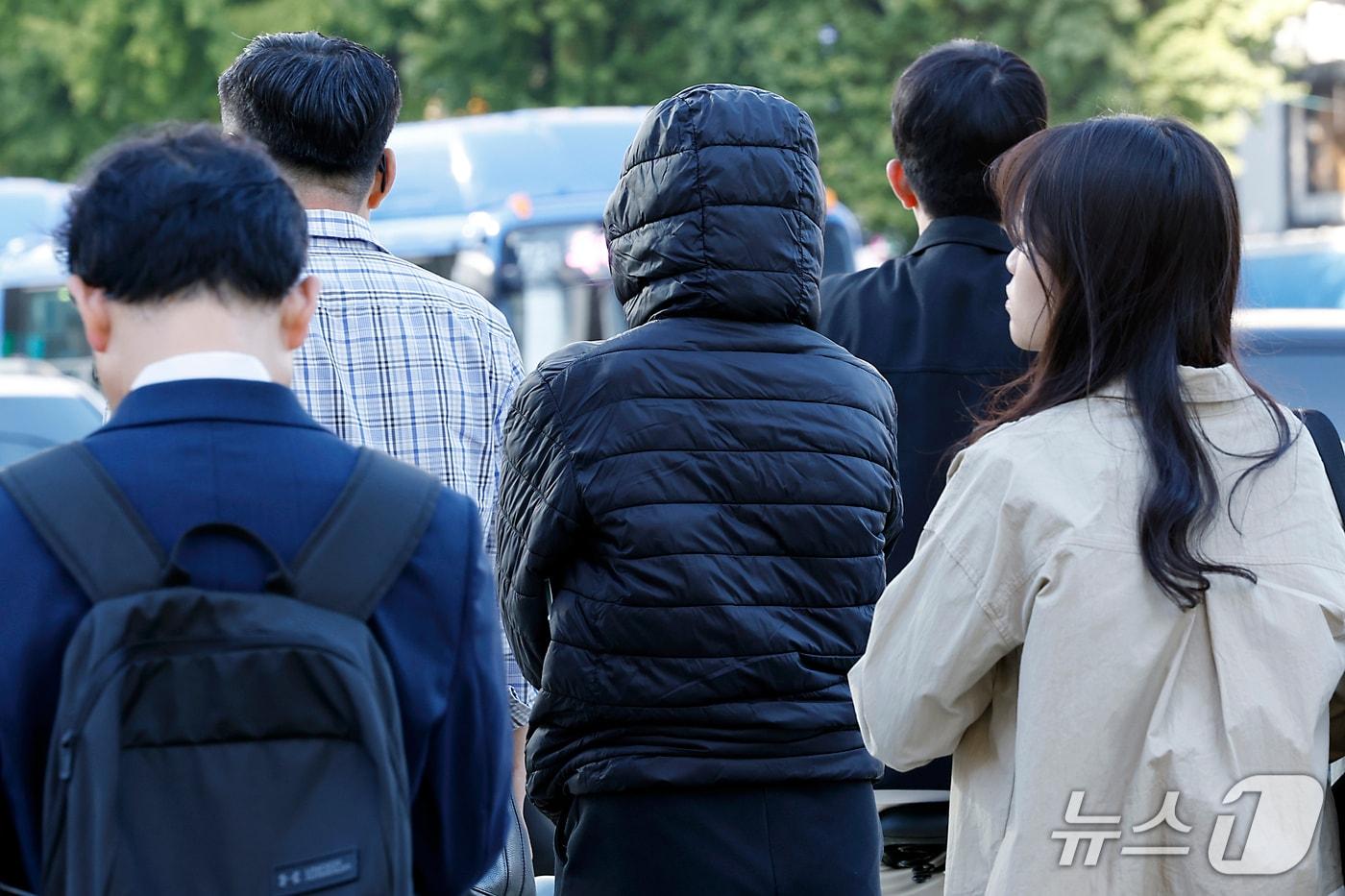 본문 이미지 - 아침 기온이 10도 안팎으로 쌀쌀한 날씨를 보인 7일 오전 서울 종로구 광화문 사거리를 지나 출근길에 오른 시민들이 옷깃을 여민 채 건널목 신호를 기다리고 있다. 2026.10.7 ⓒ 뉴스1 박정호 기자