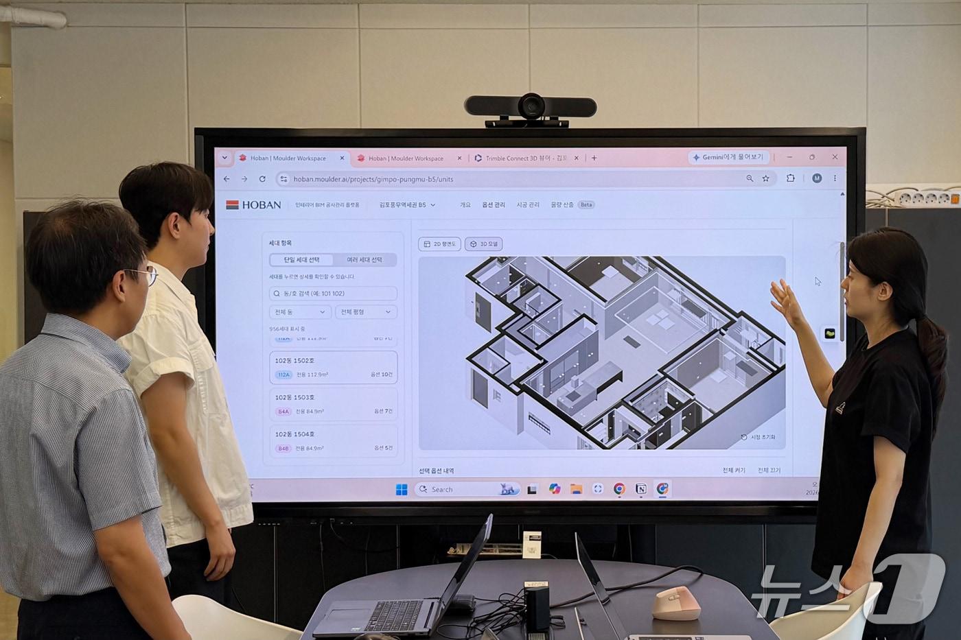 본문 이미지 - 호반건설 임직원들이 AI 기반 공동주택 세대별 BIM 자동 생성 기술을 활용해 각 세대의 옵션 현황을 확인하고 있다.