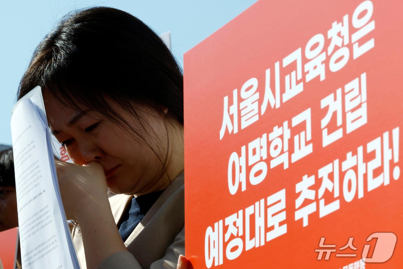본문 이미지 - 엄에스더 여명학교 졸업생이 7일 오전 서울시 중구 서울시의회 앞에서 열린 여명학교 교사 건립 촉구 기자회견에서 조명숙 교장 발언에 흐르는 눈물을 훔치고 있다. 이들은 서울 강서구 옛 염강초등학교 부지 내 여명학교 교사 건립을 예정대로 추진할 것을 서울시교육청과 서울시의회 교육위원회에 촉구했다. 2026.10.7 ⓒ 뉴스1 박정호 기자