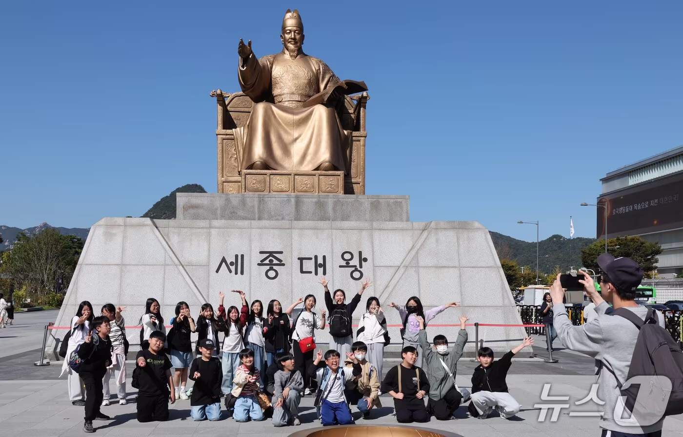 본문 이미지 - 한글날을 이틀 앞둔 7일 서울 종로구 광화문광장 세종대왕 동상 앞에서 견학 온 초등학생들이 기념촬영 하고 있다. 2026.10.7 ⓒ 뉴스1 이종덕 기자