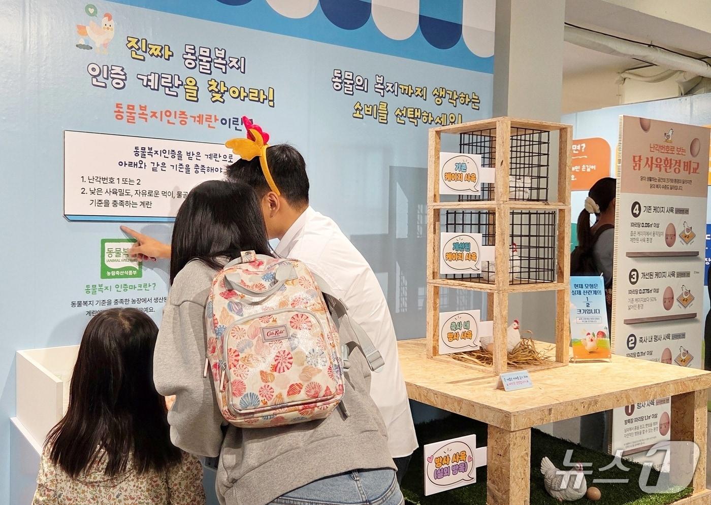 본문 이미지 - 2일 열린 '동물보호의 날' 팝업스토에서 행사 관계자가 참관객에게 동물복지 댤걀을 설명하고 있다. ⓒ 뉴스1