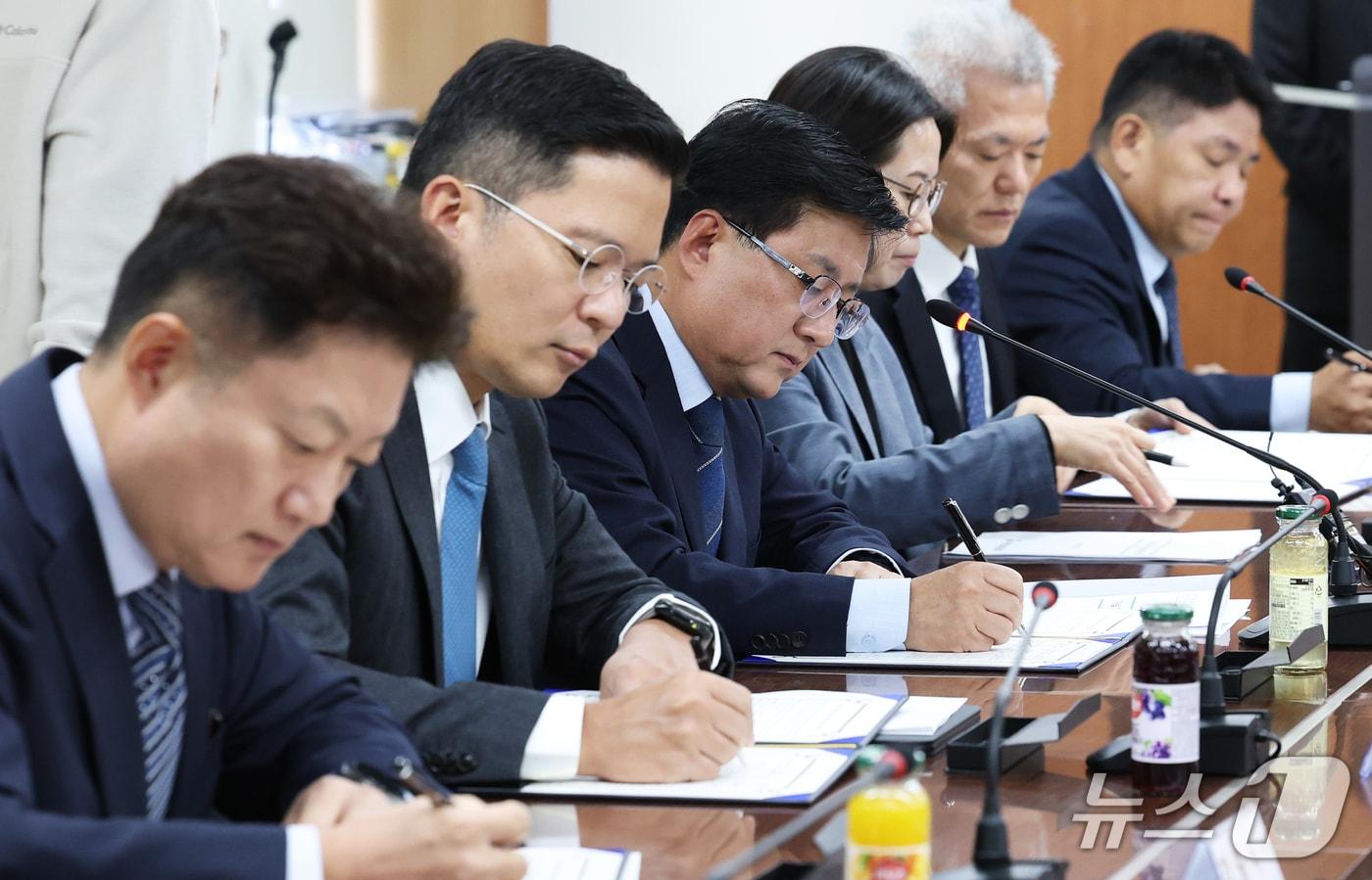 본문 이미지 - 김성환 기후에너지환경부 장관(왼쪽 세번째)이 8일 오전 서울 종로구 석탄회관에서 열린 '가습기살균제 배상 이행 업무협약식'에서 배상 참여 기업 대표들과 함께 협약서에 서명하고 있다. 2026.10.8 ⓒ 뉴스1 오대일 기자