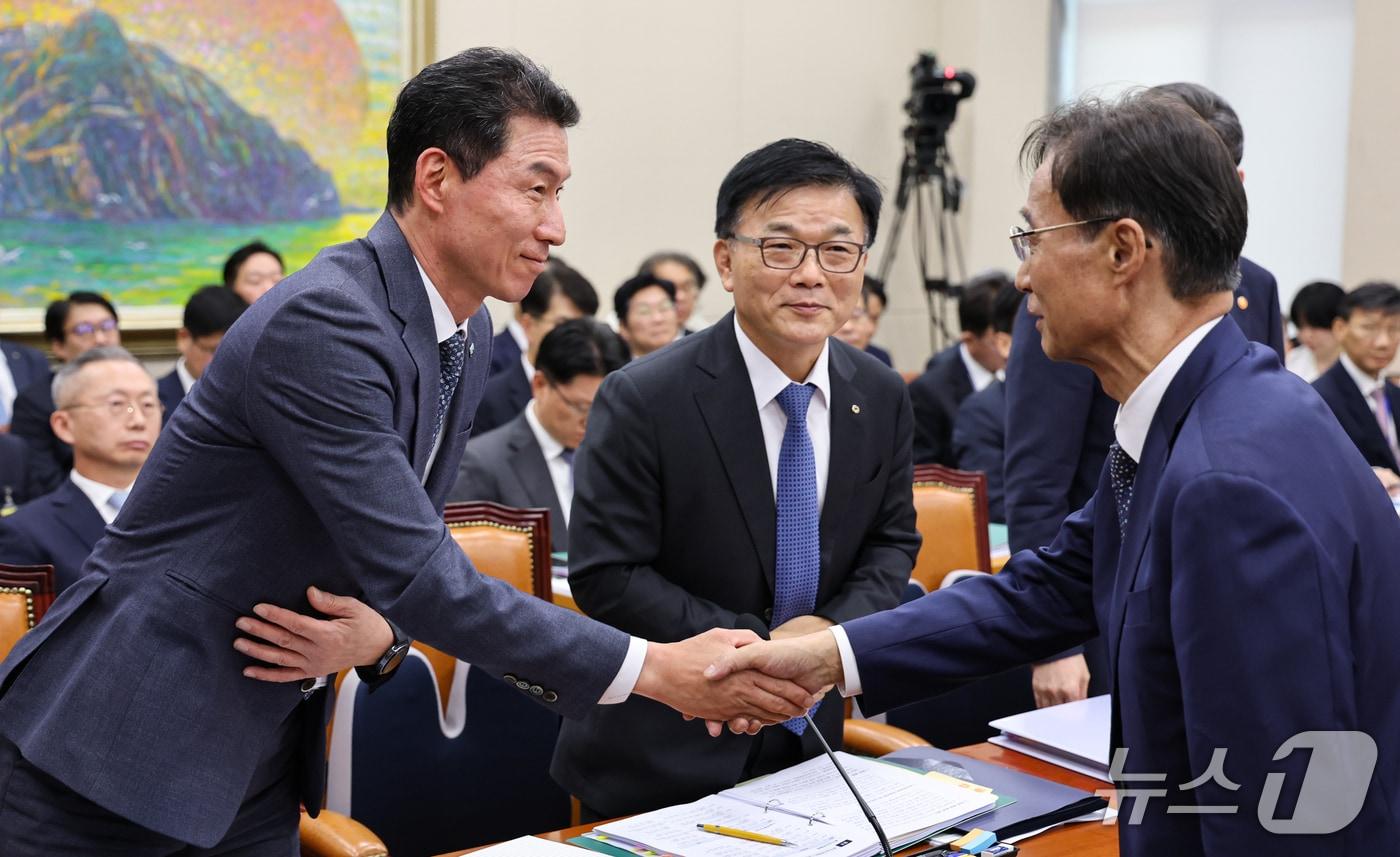 본문 이미지 - 장민영 IBK기업은행장과 박상진 한국산업은행 회장이 8일 서울 여의도 국회에서 열린 정무위원회 국정감사에 출석해 유동수 정무위원장과 인사를 나누고 있다. 2026.10.8 ⓒ 뉴스1 김도우 기자