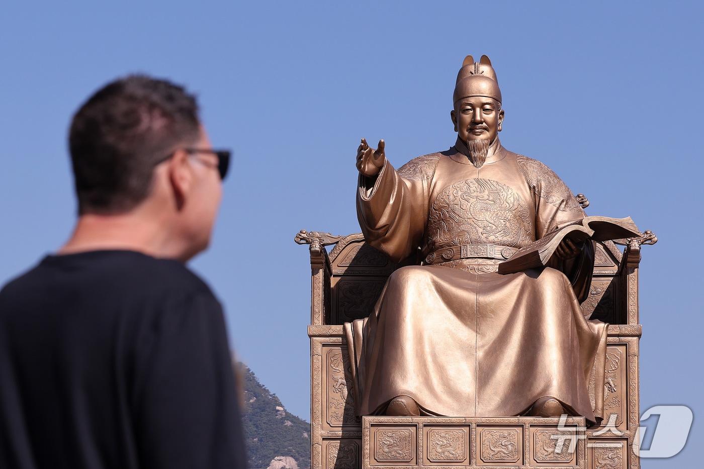본문 이미지 - 한글날 제정 100주년을 하루 앞둔 8일 서울 종로구 광과문광장에서 시민들과 외국인 관광객이 세종대왕 동상을 바라보고 있다. 올해는 세종대왕의 한글 창제 580돌이며, 한글날 제정 100주년이다. 2026.10.8 ⓒ 뉴스1 박지혜 기자