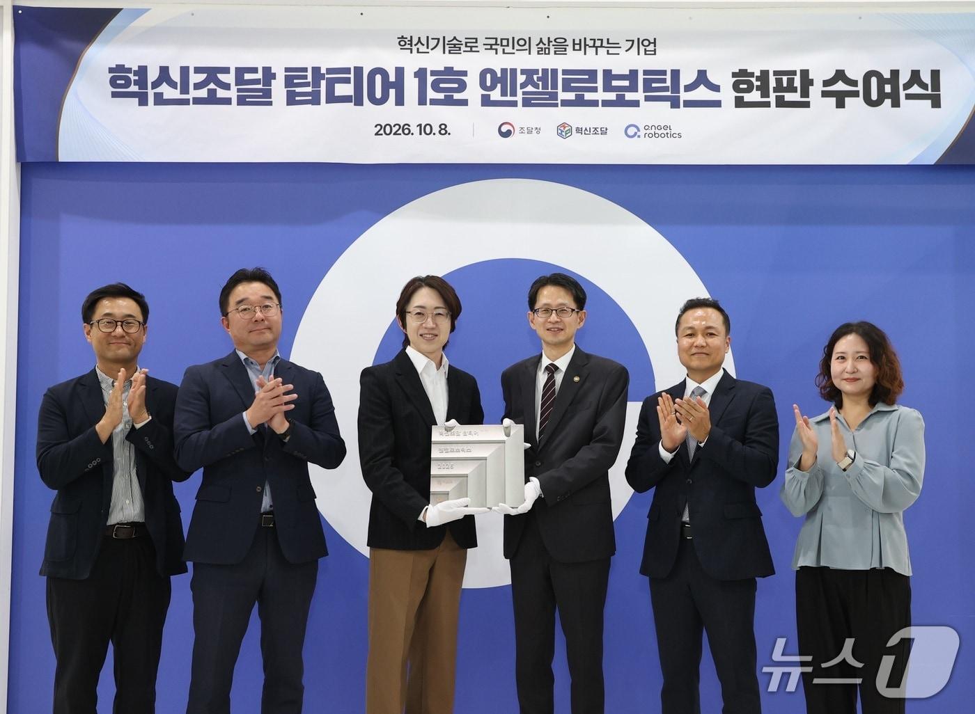 본문 이미지 - 백승보 조달청장(왼쪽 네번째)이 혁신기업 탑티어 1호기업인 ㈜엔젤로보틱스를 방문하여 관계자들과 기념촬영을 하고 있다. (조달청 제공. 재판매 및 DB금지) /뉴스1