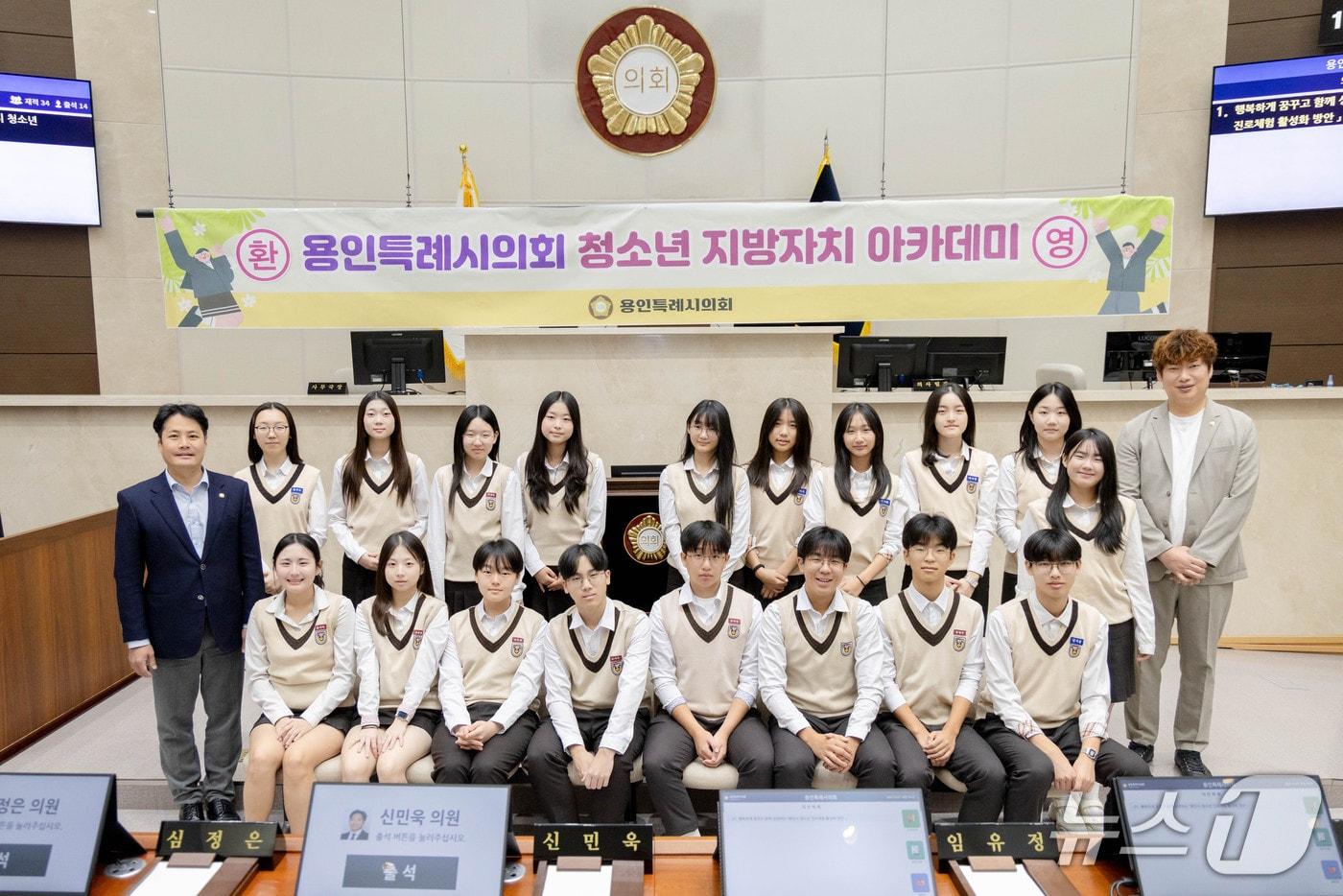 본문 이미지 - 용인대덕중 학생들이 용인시의회 본회의장에서 기념 촬영을 하고 있는 모습.(시의회 제공)