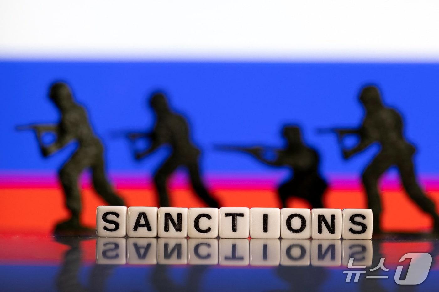 본문 이미지 - 러시아 국기를 배경으로 한 '재재'(sanctions) 문자 일러스트. 2022.2.25 ⓒ 로이터=뉴스1