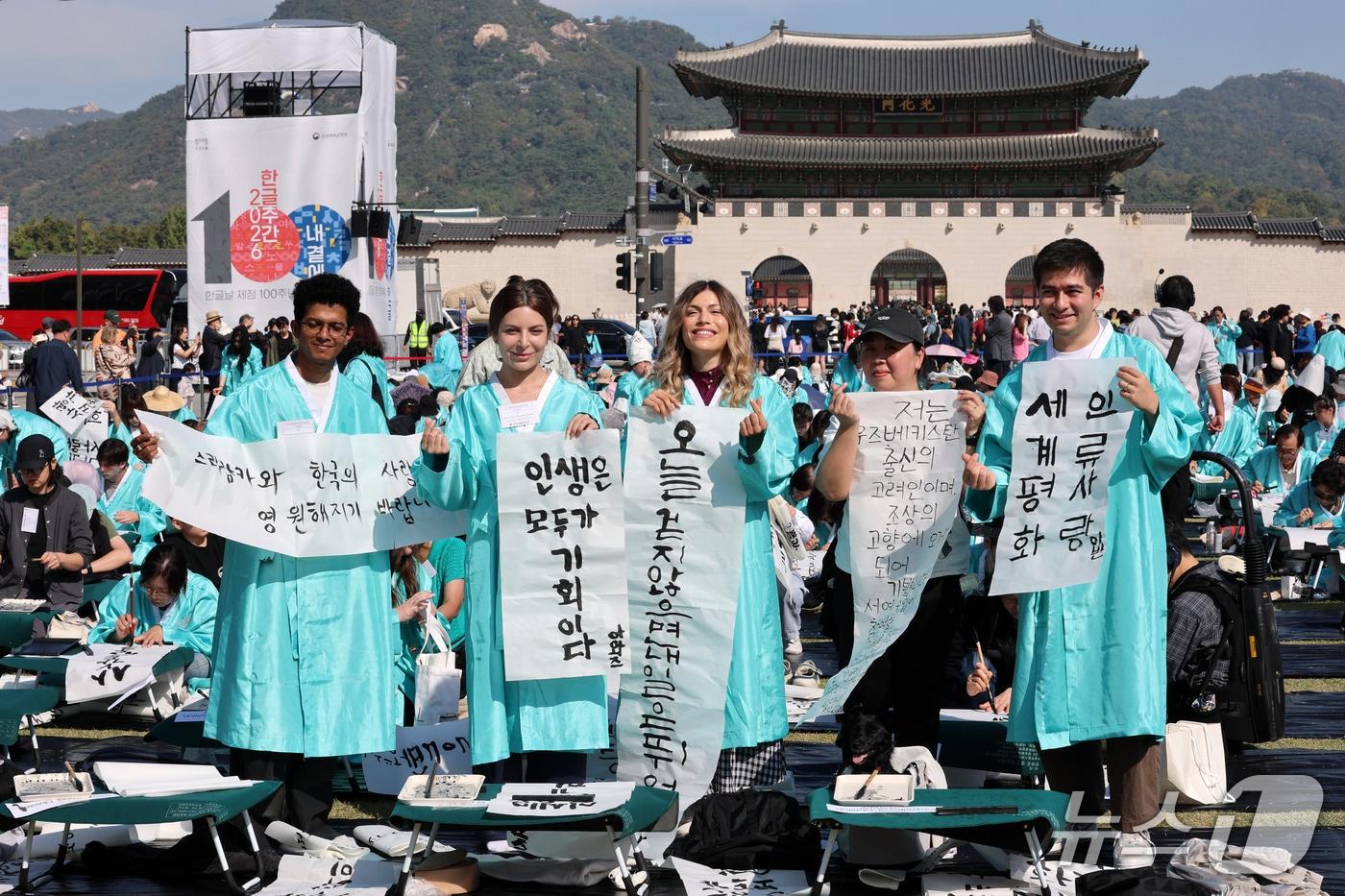 본문 이미지 - 한글날인 9일 오전 서울 광화문광장에서 한국예술문화원 주최로 열린 '광화문광장 휘호대회'에서 외국인 참가자들이 직접 쓴 한글 휘호를 들어 보이고 있다. 2026.10.9 ⓒ 뉴스1 박세연 기자