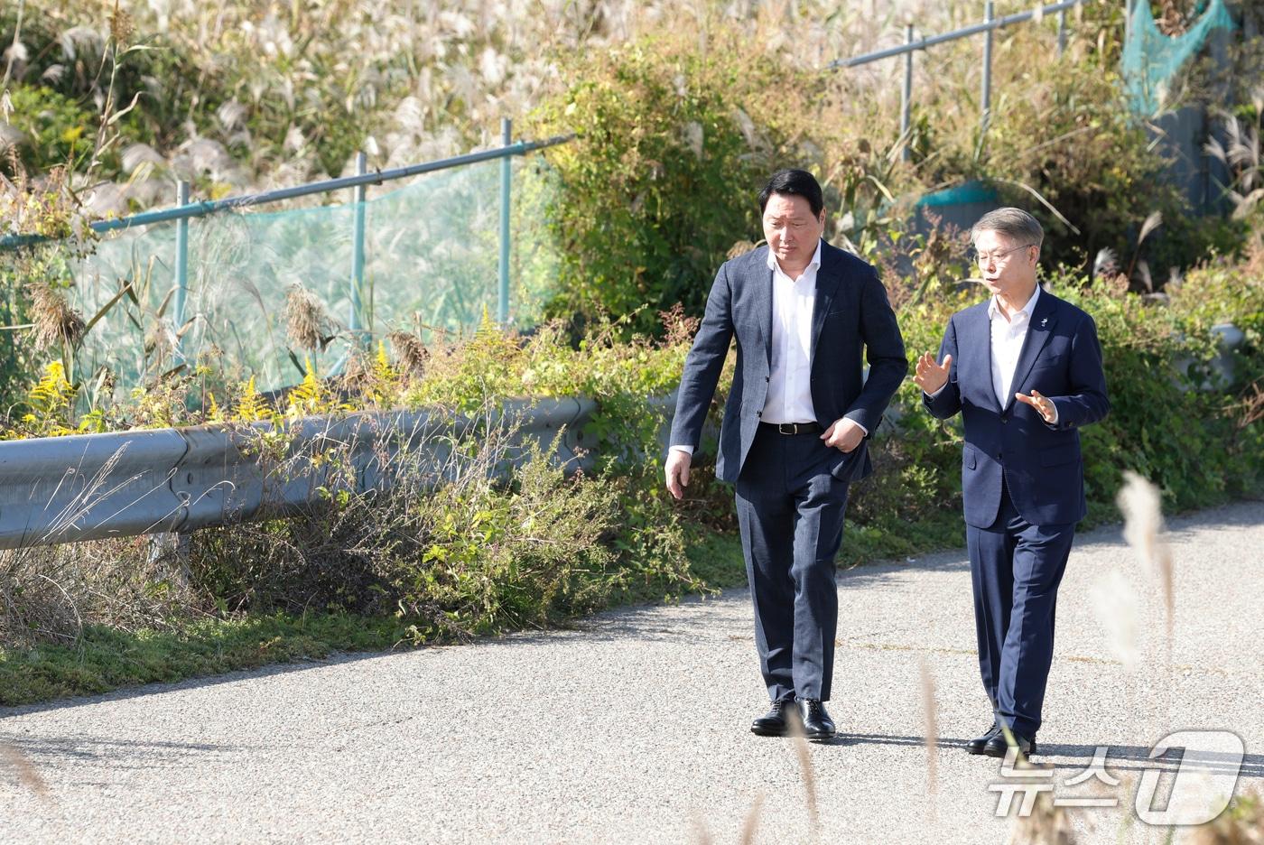 본문 이미지 - 최태원 SK 그룹 회장과 민형배 전남광주통합특별시장이 9일 광주 군공항 탄약고 이전 예정지를 찾아 호남권 반도체 산단 조성 예정 부지를 살펴보고 있다. 2026.10.9 ⓒ 뉴스1 김태성 기자