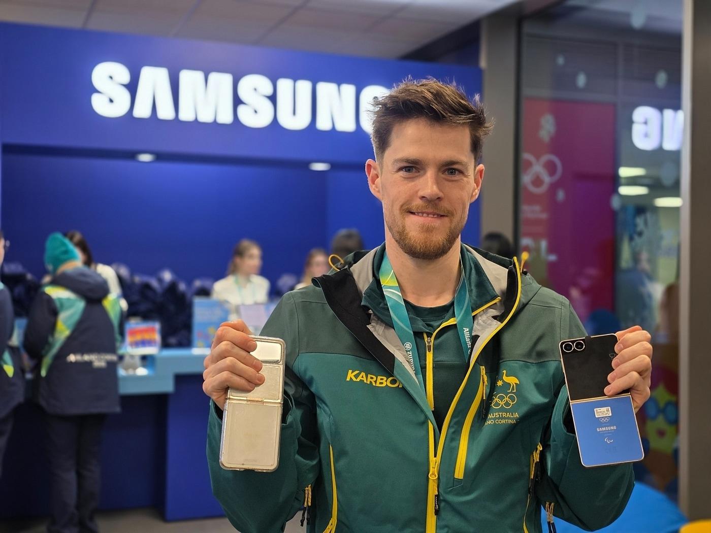 본문 이미지 - 브렌던 코리 (Brendan Corey / 호주, 스피드 스케이팅) 선수가 밀라노 올림픽 선수촌 내 삼성 체험관에 방문해 갤럭시 Z 플립7 올림픽 에디션과 지난 베이징 동계올림픽 갤럭시 Z 플립3 올림픽 에디션을 함께 보여주고 있다.(삼성전자 제공)