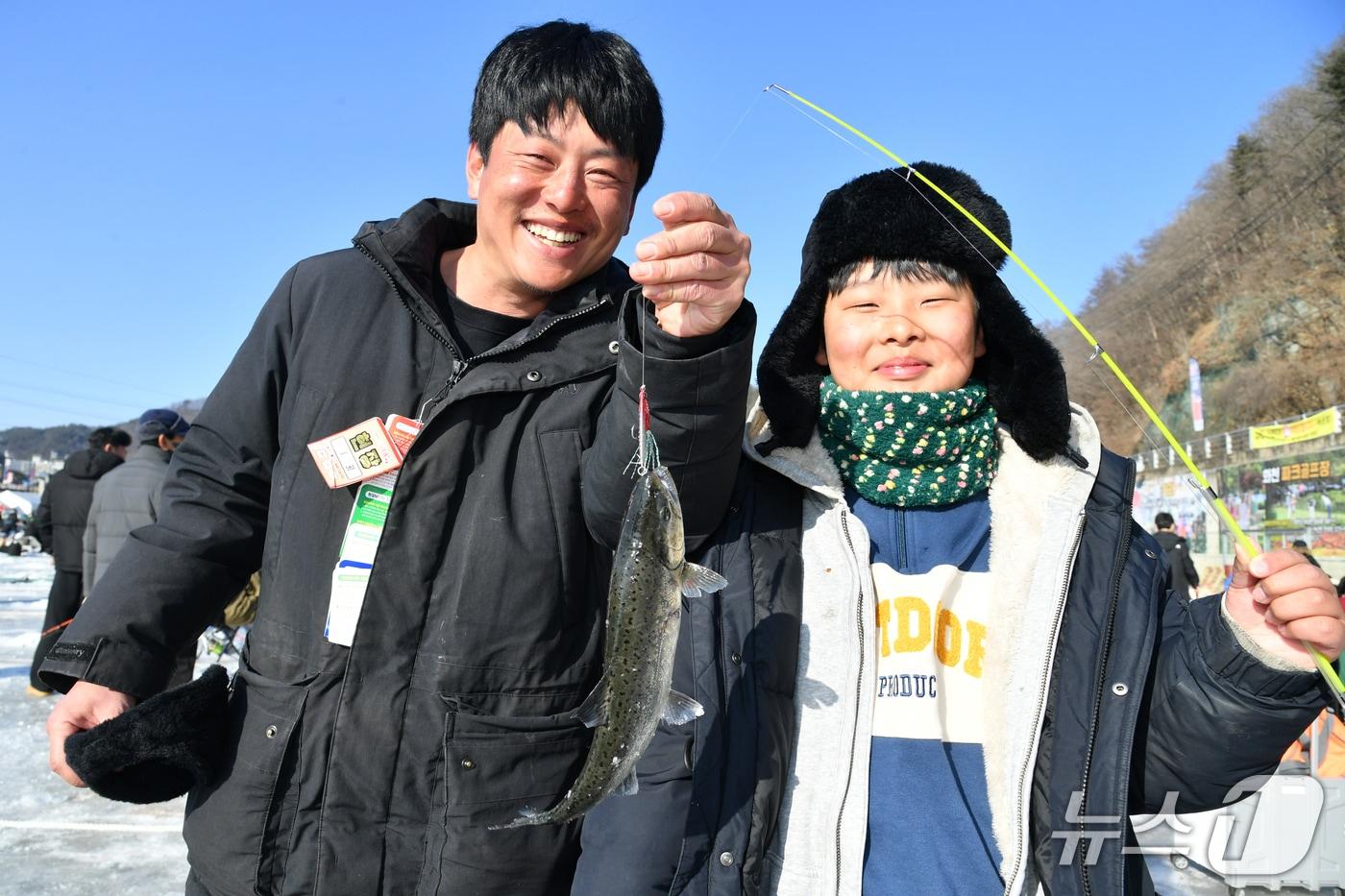 본문 이미지 - 2026 화천산천어축제 전 기간, 산천어 얼음낚시터를 찾은 이은성 군과 아버지 이용민 씨.(화천군 제공, 재판매 및 DB금지)