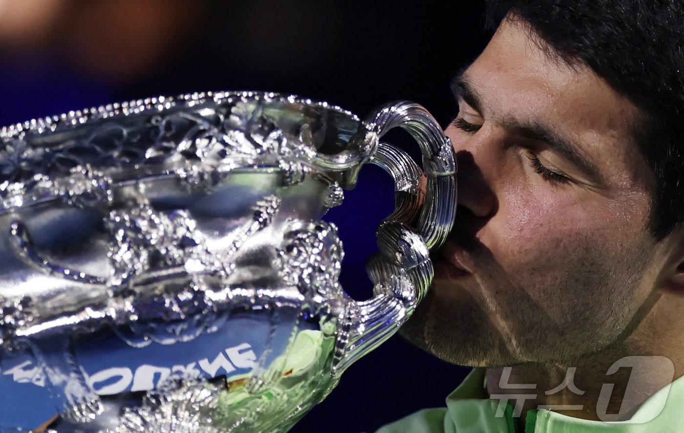 본문 이미지 - 카를로스 알카라스(스페인)가 1일 호주 멜버른에서 열린 호주오픈 테니스 대회 남자 단식 결승에서 노박 조코비치(세르비아)를 꺾고 우승을 차지, 우승컵인 노먼 브룩스 챌린지컵에 입맞추고 있다.  ⓒ 로이터=뉴스1 