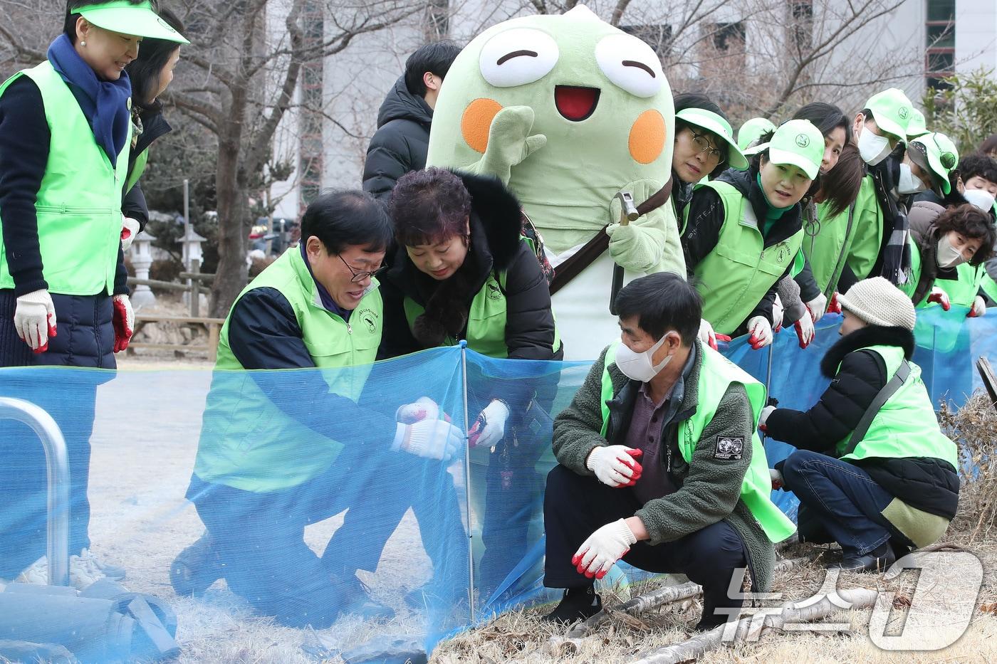 본문 이미지 - 10일 오후 대구 수성구 욱수동 망월지에서 열린 '두꺼비 로드킬 방지 펜스 설치 행사'에 참여한 김대권 수성구청장과 구청 녹색환경과 직원, 자연보호대구시협의회원, 두꺼비를 형상화 한 수성구 대표 마스코트 '뚜비'와 함께 펜스를 설치하고 있다. 2026.2.10 ⓒ 뉴스1 공정식 기자
