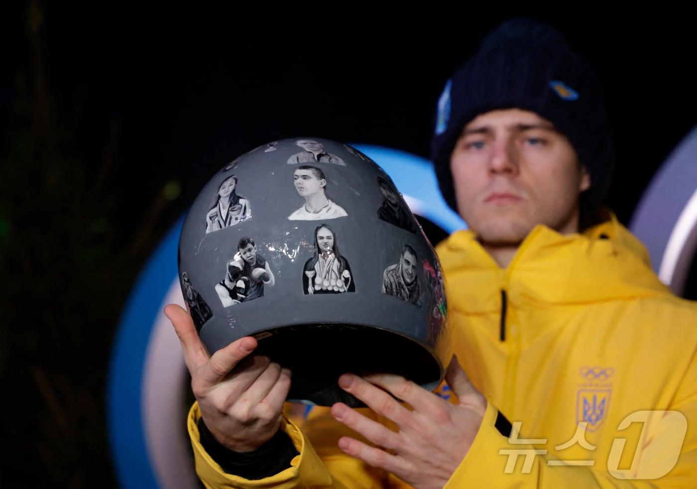 본문 이미지 - 우크라이나 스켈레톤 국가대표 블라디슬라프 헤라스케비치가 10일(현지시각) 이탈리아 코르티나담페초에서의 기자회견 중 러시아의 우크라이나 공격으로 사망한 선수들을 기리는 헬멧을 보여주고 있다. ⓒ 로이터=뉴스1
