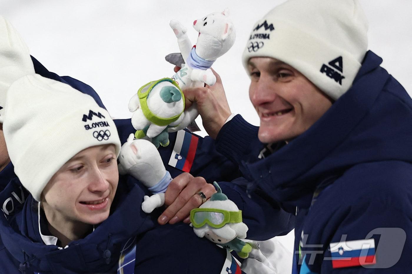 본문 이미지 - 슬로베니아의 니카 프레브츠(왼쪽)와 도멘 프레브츠가 10일(현지시각) 이탈리아 프레다초에서 열린 2026 밀라노·코르티나담페초 동계올림픽 스키점프 혼성 단체전 결승전 포디움에서 축하하고 있다. ⓒ AFP=뉴스1