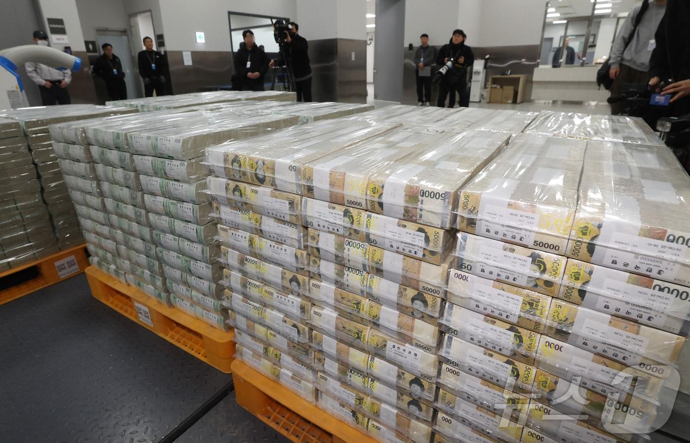 본문 이미지 - 설날을 앞둔 11일 서울 중구 한국은행 본점에서 현금 운송 관계자들이 시중은행에 공급될 설 자금 방출 작업을 하고 있다. 2026.2.11 ⓒ 뉴스1 사진공동취재단