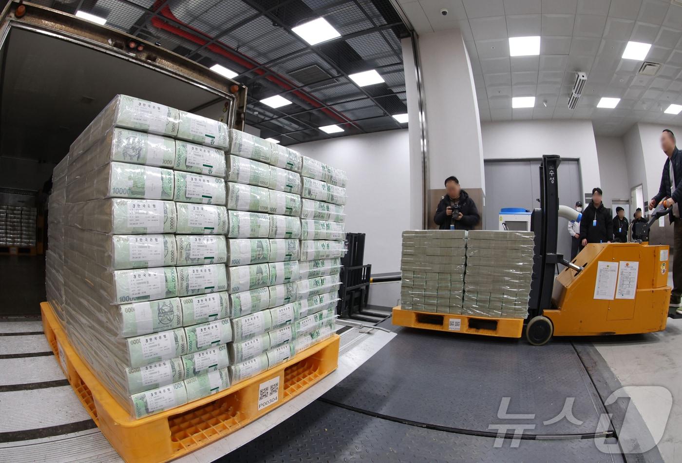 본문 이미지 - 설날을 앞둔 11일 서울 중구 한국은행 본점에서 현금 운송 관계자들이 시중은행에 공급될 설 자금 방출 작업을 하고 있다. 2026.2.11 ⓒ 뉴스1 사진공동취재단
