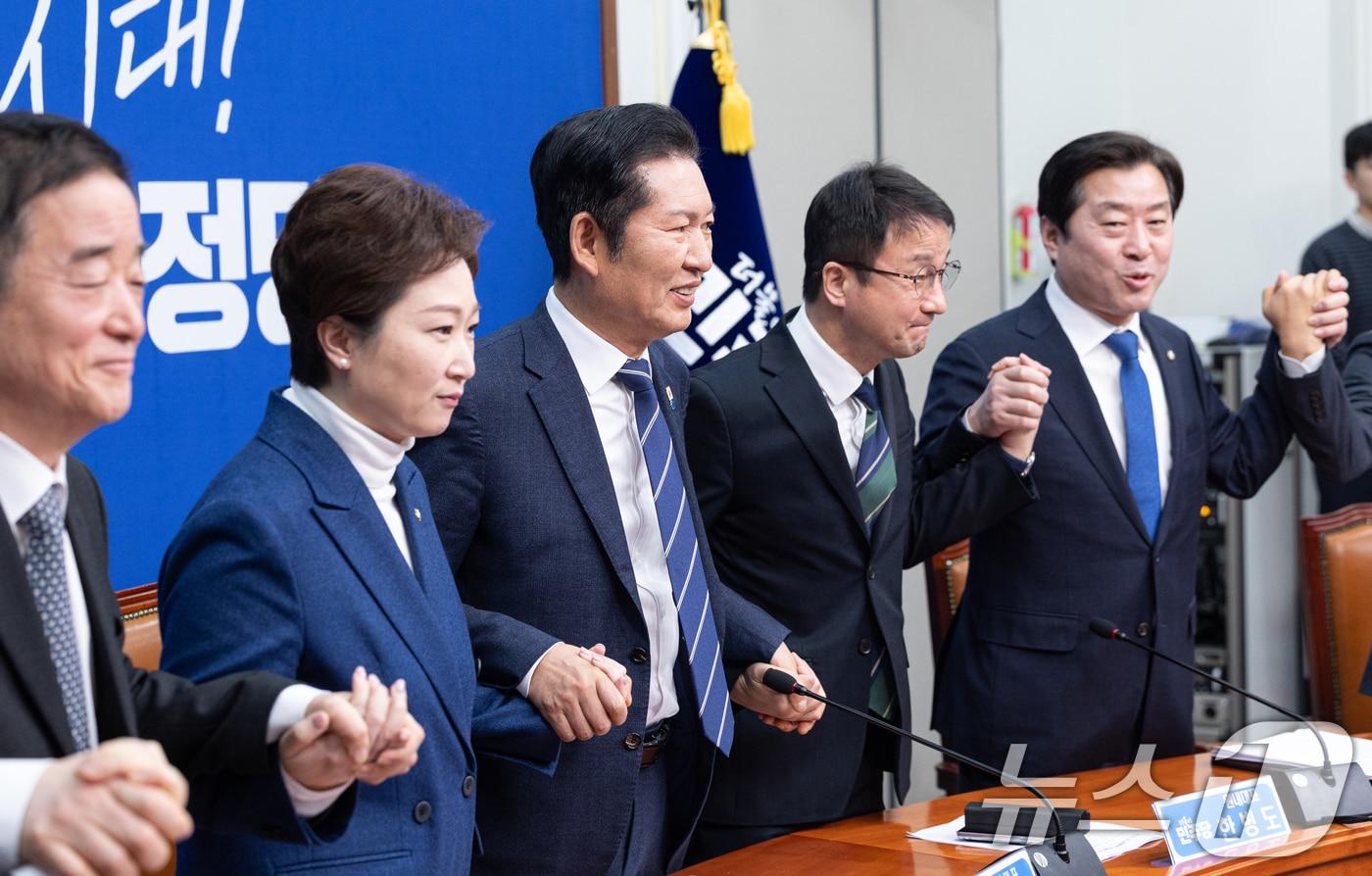 본문 이미지 - 정청래 더불어민주당 대표가 11일 서울 여의도 국회에서 열린 최고위원회의에서 최고위원들과 손을 맞잡고 있다. 2026.2.11 ⓒ 뉴스1 이승배 기자