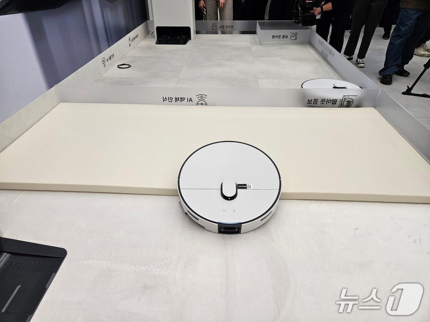 본문 이미지 - 삼성전자가 2026년형 '비스포크 AI 스팀' 로봇청소기를 11일 공개했다. 로봇청소기가 방지턱을 넘고 있는 모습.ⓒ 뉴스1/김진희 기자.