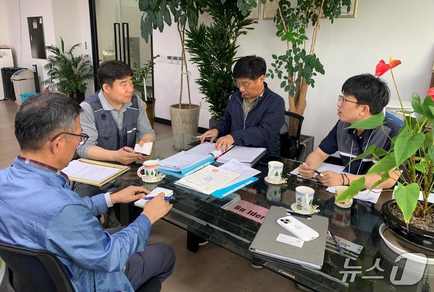 본문 이미지 - 한강청과 녹색환경지원센터 관계자들이 지난해 5월 21일 화성시 마도면의 한 창호 제조업체에서 맞춤형 기술지원을 하고 있는 모습.(한강청 제공)