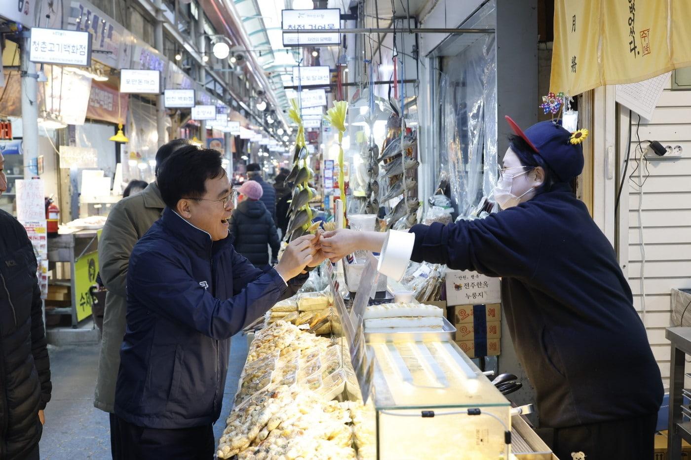 본문 이미지 - 진교훈 서울 강서구청장(왼쪽)이 11일 설 명절을 앞두고 까치산시장을 찾아 상인과 인사를 나누고 있다.