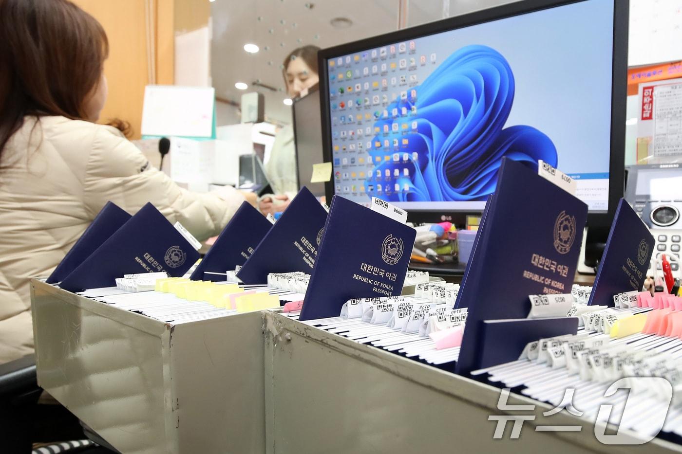 본문 이미지 - 설 연휴를 앞두고 여권 발급 신청이 늘고 있다. 11일 오후 대구 달서구청 민원실 여권 교부처에서 담당 직원이 신규 발급된 여권을 민원인에게 전달하고 있다. 2026.2.11 ⓒ 뉴스1 공정식 기자