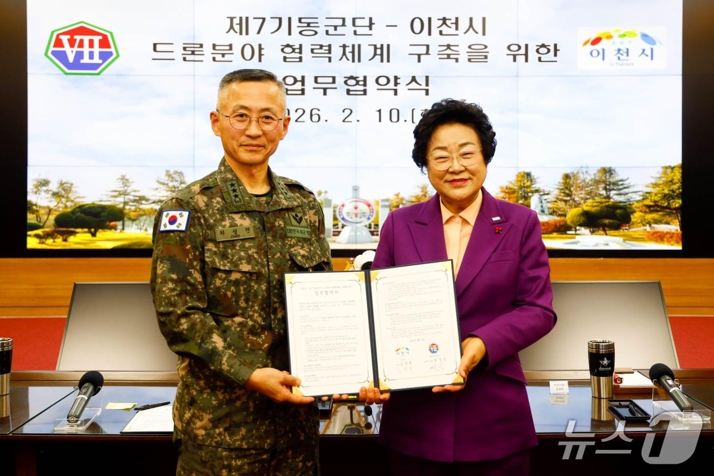 본문 이미지 - 김경희 시장(오른쪽)과 최성진 제7기동군단장이 업무협약을 체결한 뒤 기념촬영을 하고 있는 모습.(이천시 제공)