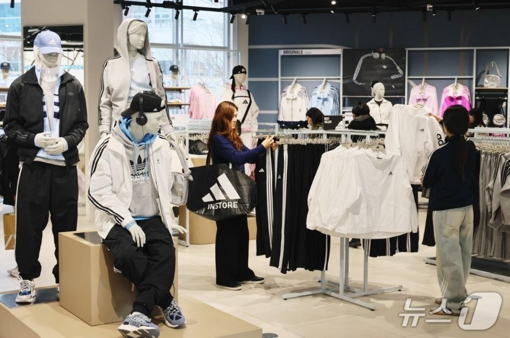 본문 이미지 - 롯데아울렛 이시아폴리스점 1층 아디다스 매장에서 고객이 스포츠 상품을 살펴보고 있다.(롯데백화점 제공, 재판매 및 DB 금지)
