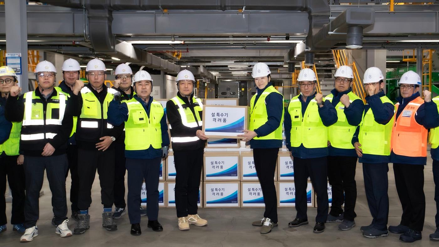 본문 이미지 - 노삼석 대표이사 사장(앞줄 왼쪽 네 번째)과 조현민 사장(앞줄 오른쪽 다섯 번째)이 종사자들에게 격려품을 전달하며 기념사진을 찍고 있다.(한진 제공)