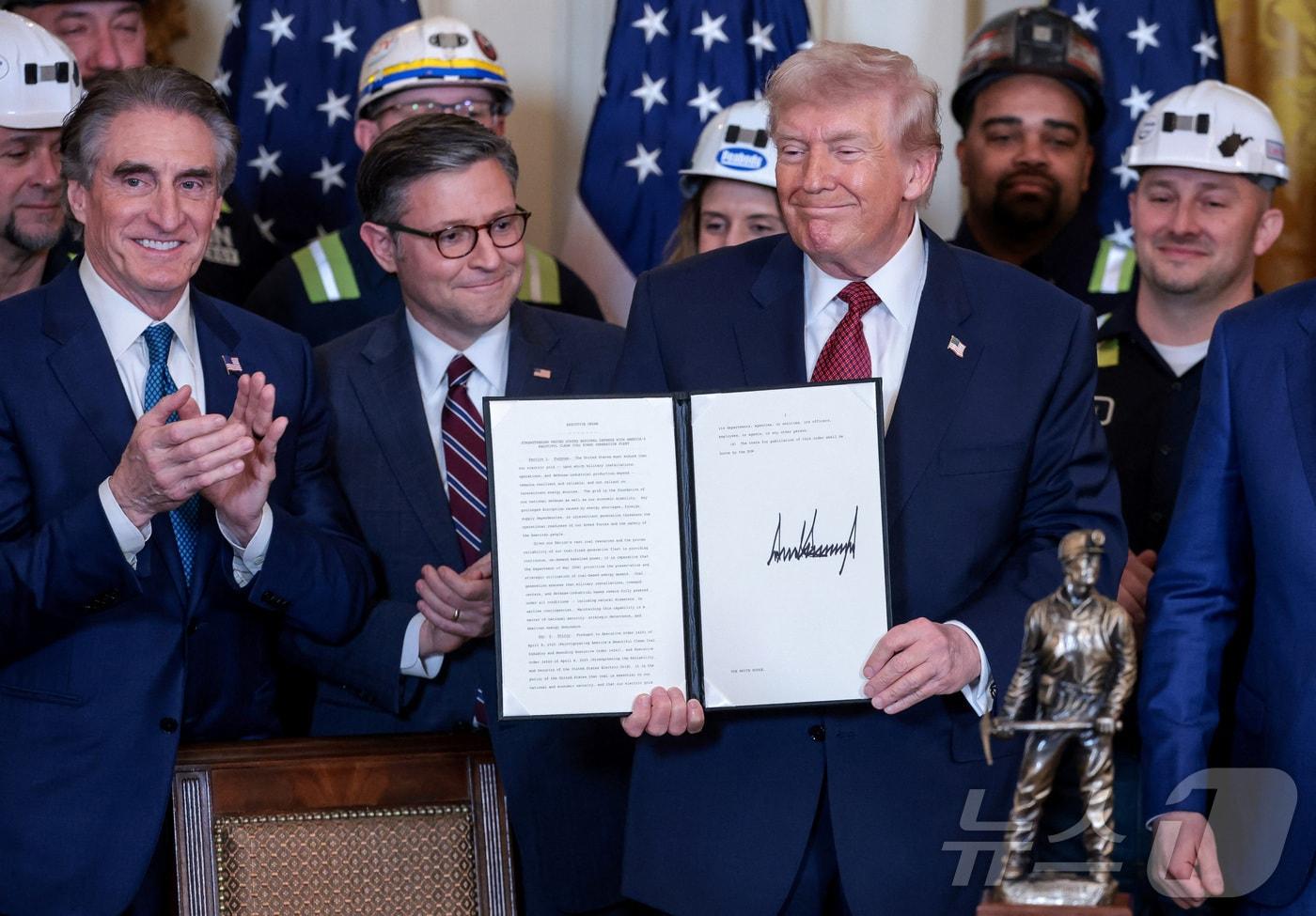 본문 이미지 - 도널드 트럼프 미국 대통령이 11일(현지시간) 워싱턴DC 백악관 이스트룸에서 열린 석탄 발전 장려 행사에서 '미국의 아름다운 청정 석탄 발전을 통한 국가안보 강화'라는 제목의 행정명령에 서명한 뒤 이를 들어 보이고 있다. 2026.02.11. ⓒ 로이터=뉴스1