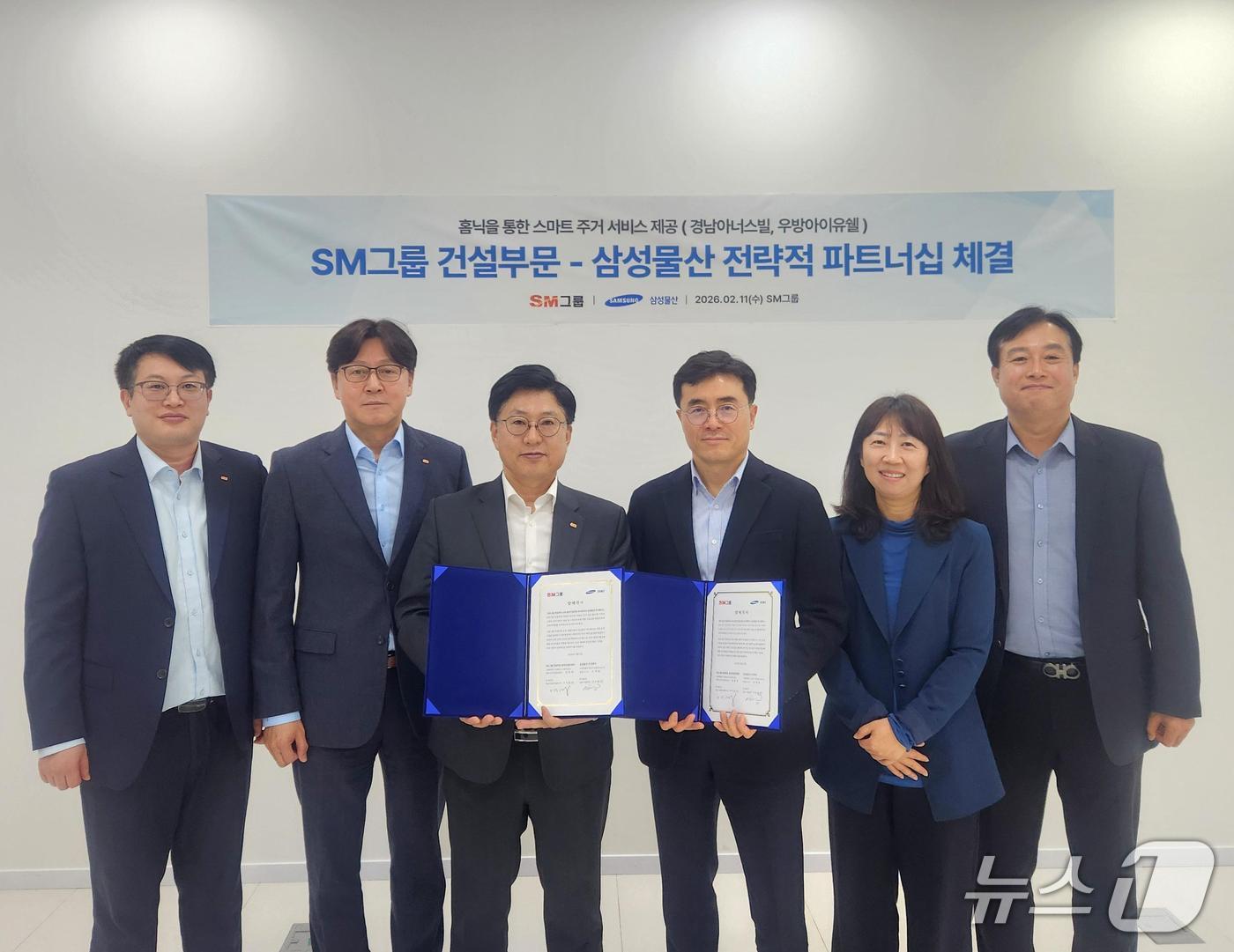 본문 이미지 - 임동복 SM그룹 건설부문장 (왼쪽 세 번째)과 이주용 삼성물산 건설부문 DxP사업부장(오른쪽 세 번째)이 지난 11일 서울 서대문구 SM그룹 신촌사옥에서 홈플랫폼 '홈닉'(Homeniq)을 통한 스마트 주거 서비스 기술교류 협력을 위한 양해각서를 체결한 뒤 양 사 주요 참석자들과 기념촬영을 하고 있다. (SM그룹 제공) 뉴스1 ⓒ News1