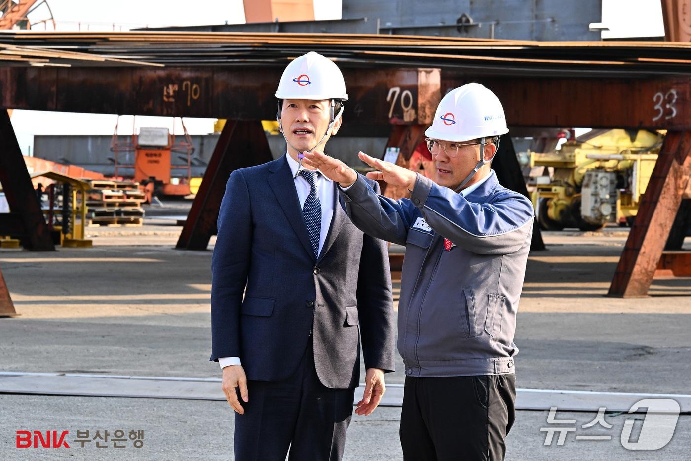 본문 이미지 - 김성주 BNK부산은행장(왼쪽)이 지난 11일 HSG성동조선 현장을 방문해 설명을 듣고 있다. (부산은행 제공. 재판매 및 DB금지)