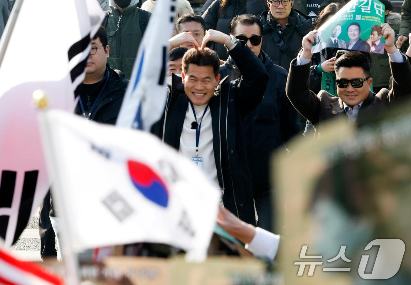 본문 이미지 - 이재명 대통령과 김현지 청와대제1부속실장에 대한 허위 사실을 유포한 혐의로 고발된 한국사 강사 출신 보수 유튜버 전한길 씨가 12일 오전 서울시 동작구 노량진역 앞에서 피의자 신분 경찰 첫 소환 조사 출석에 앞서 입장을 밝힌 후 지지자들에게 인사를 하고 있다. 2026.2.12 ⓒ 뉴스1 박정호 기자