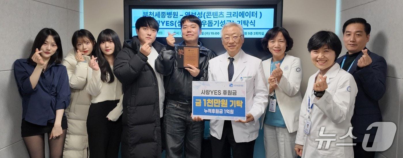 본문 이미지 - 콘텐츠 크리에이터 염보성 씨(왼쪽에서 5번째)가 동료들과 함께 부천성모병원에 후원금 1000만 원을 전달했다.(경기 부천세종병원 제공/뉴스1)