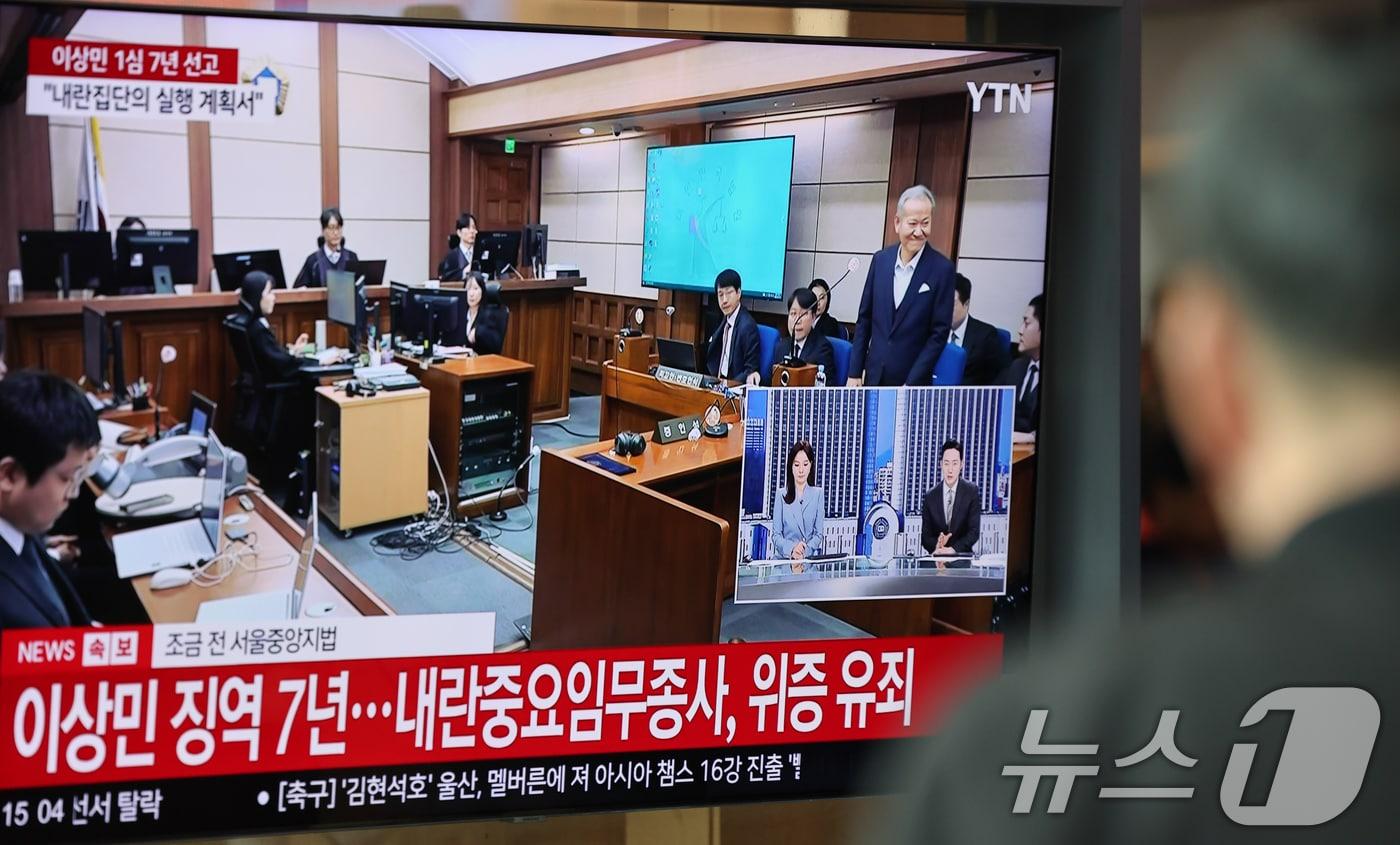 본문 이미지 - 12·3 비상계엄 당시 언론사 단전·단수 지시 혐의를 받는 이상민 전 행정안전부 장관의 1심 선고일인 12일 서울역 대합실에서 선고 생중계가 나오는 가운데 재판부가 징역 7년을 선고하고 있다. 2026.2.12 ⓒ 뉴스1 안은나 기자