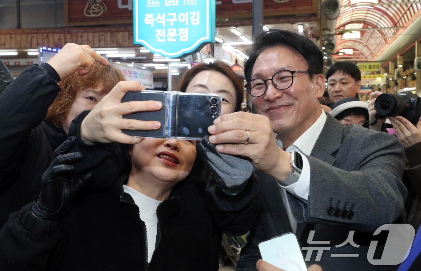 본문 이미지 - 김민석 국무총리가 지난 12일 오후 설 명절을 앞두고 충북 청주시 육거리종합시장을 방문해 상인들과 사진촬영을 하고 있다. 2026.2.12 ⓒ 뉴스1 김용빈 기자