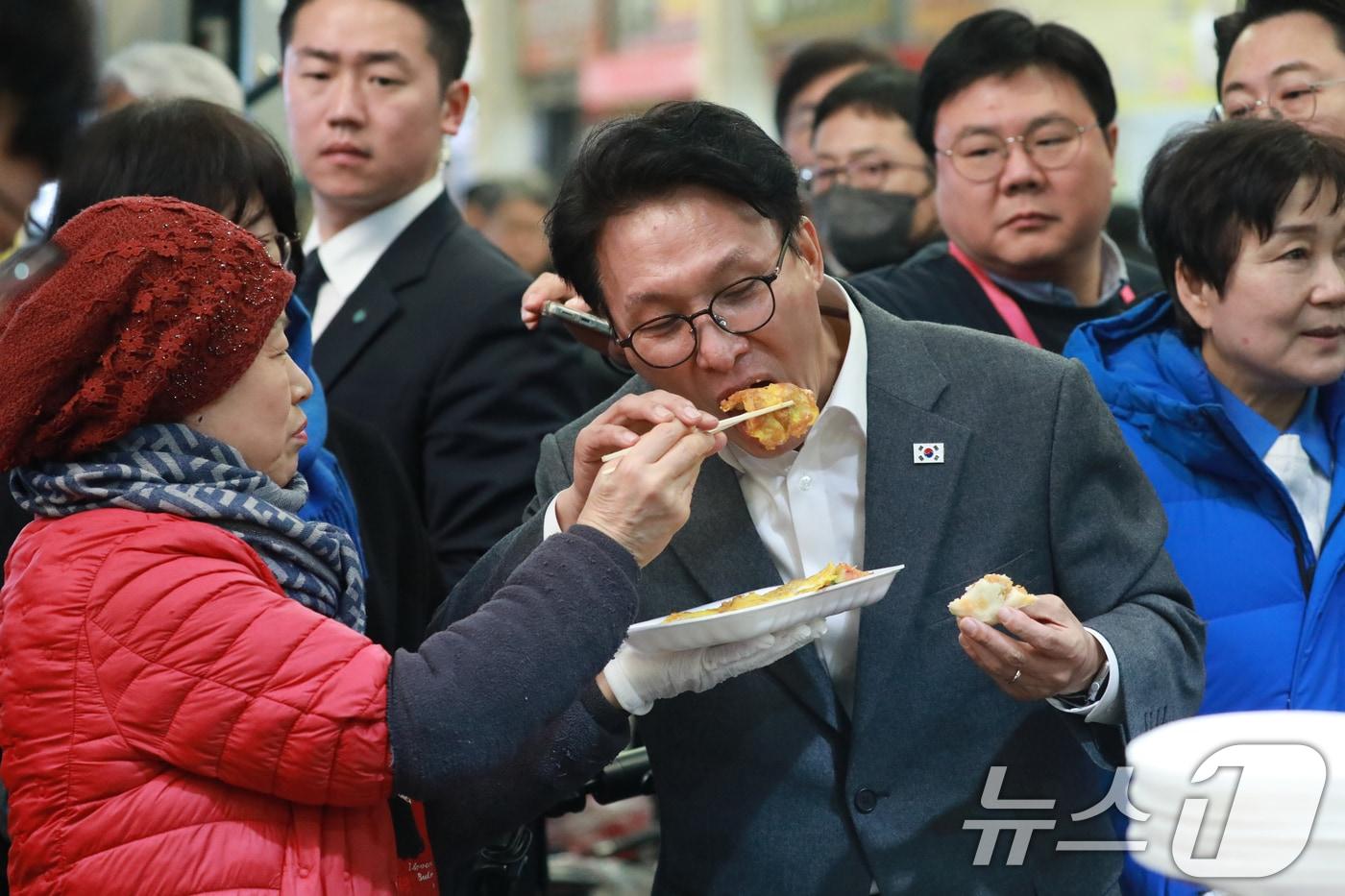 본문 이미지 - 김민석 국무총리가 지난 12일 오후 설 명절을 앞두고 충북 청주시 육거리종합시장을 방문, 상인이 주는 전을 맛보고 있다. 2026.2.12 ⓒ 뉴스1 김용빈 기자