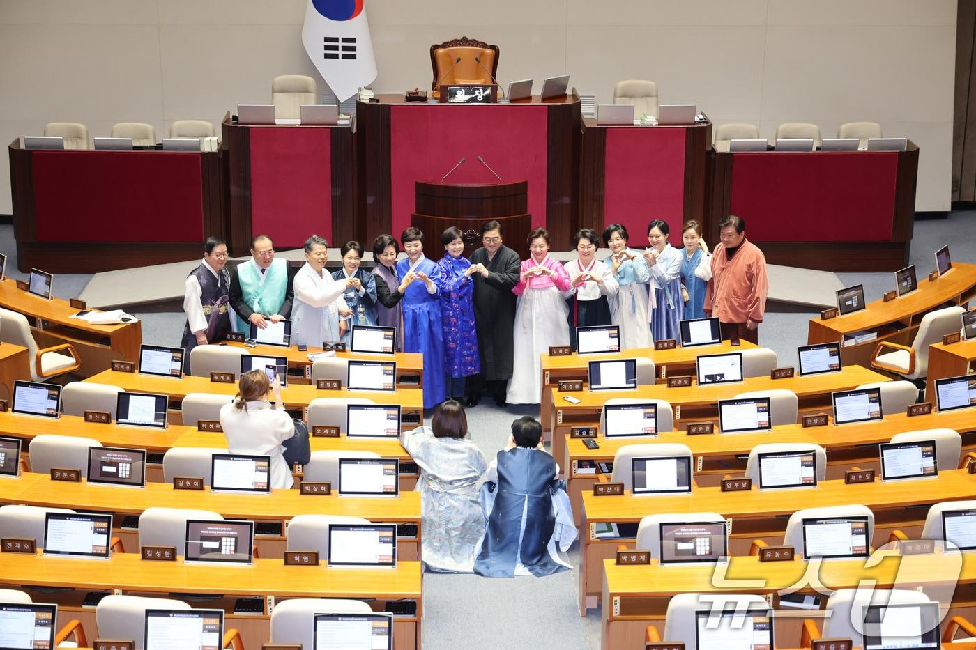 본문 이미지 - 우원식 국회의장이 12일 서울 여의도 국회에서 열린 제432회국회(임시회) 제7차 본회의가 산회된 후 한복을 입은 의원들과 기념 촬영을 하고 있다. 2026.2.12 ⓒ 뉴스1 신웅수 기자
