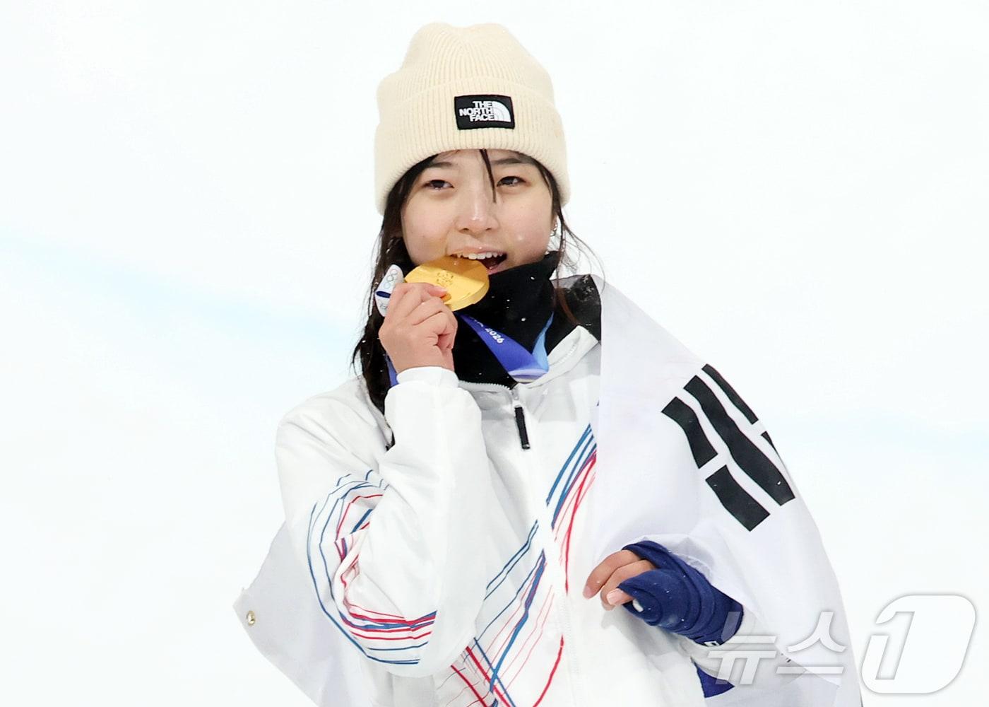 본문 이미지 - 12일(현지시간) 이탈리아 리비뇨 스노파크에서 열린 2026 밀라노·코르티나담페초 동계올림픽 스노보드 여자 하프파이프 결선에서 90.25점을 받아 금메달을 획득한 스노보드 최가온이 금메달을 깨물며 기뻐하고 있다. 2026.2.13 ⓒ 뉴스1 김진환 기자