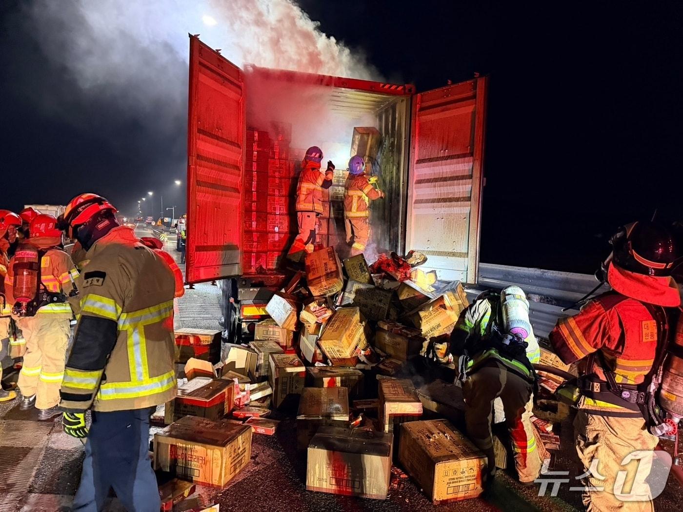 본문 이미지 - 13일 오전 2시32분쯤 경북 고령군 개진면 부리 중부내륙고속도로 양평 방향 개진졸음쉼터 인근을 달리던 24톤 트레일러에서 불이나 소방대원들이 트럭에 실린 짐을 꺼내고 있다.(경북소방본부 제공. 재판매 및 DB 금지)2026.2.13/뉴스1