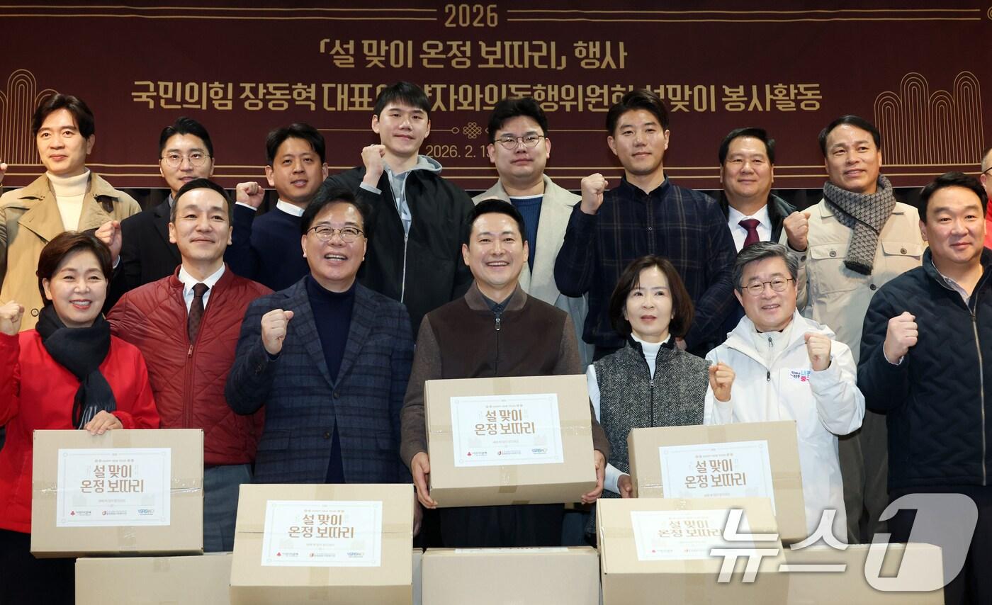 본문 이미지 - 장동혁 국민의힘 대표와 송언석 원내대표가 13일 오전 서울 중구 중림종합사회복지관에서 열린 약자와의동행위원회 설맞이 봉사활동에서 당 관계자 및 참석자들과 설 맞이 온정 보따리를 들고 기념촬영을 하고 있다. (공동취재) 2026.2.13 ⓒ 뉴스1 김명섭 기자